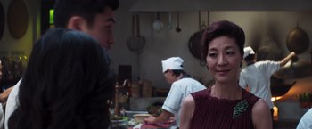 Movie still from “Crazy Rich Asians” (2018), directed by Jon M. Chu – A group of people standing around a kitchen; Close Up shot, Over the shoulder angle