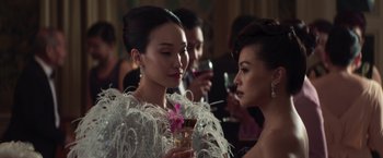 Movie still from “Crazy Rich Asians” (2018), directed by Jon M. Chu – Two women are talking and drinking at an event; Close Up shot, Over the shoulder angle