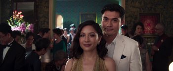 Movie still from “Crazy Rich Asians” (2018), directed by Jon M. Chu – A man and a woman posing for a picture; Close Up shot, Over the shoulder angle