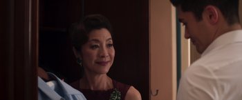 Movie still from “Crazy Rich Asians” (2018), directed by Jon M. Chu – A person wearing a dress; Close Up shot, Over the shoulder angle