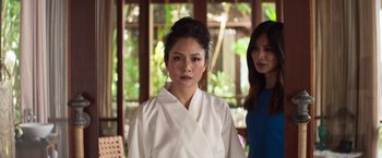 Movie still from “Crazy Rich Asians” (2018), directed by Jon M. Chu – A woman in a white robe standing next to another woman in a blue dress; Close Up shot, Over the shoulder angle