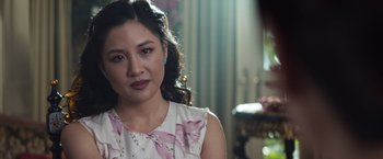 Movie still from “Crazy Rich Asians” (2018), directed by Jon M. Chu – A person wearing a dress; Close Up shot, Over the shoulder angle