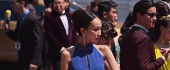 Movie still from “Crazy Rich Asians” (2018), directed by Jon M. Chu – A woman in a blue dress standing in front of a crowd; Close Up shot, Over the shoulder angle