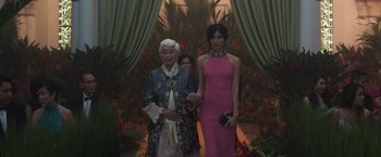 Movie still from “Crazy Rich Asians” (2018), directed by Jon M. Chu – Two women standing next to each other in front of a doorway; Medium shot, Low angle