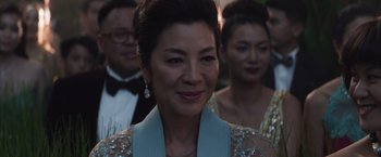 Movie still from “Crazy Rich Asians” (2018), directed by Jon M. Chu – A group of people in formal wear standing next to each other; Close Up shot, Over the shoulder angle