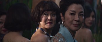 Movie still from “Crazy Rich Asians” (2018), directed by Jon M. Chu – Two women in formal wear posing for a picture; Close Up shot, Over the shoulder angle