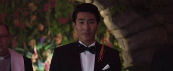 Movie still from “Crazy Rich Asians” (2018), directed by Jon M. Chu – A man in a suit and a bow tie; Close Up shot, Over the shoulder angle