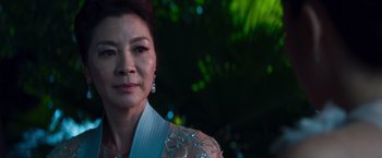 Movie still from “Crazy Rich Asians” (2018), directed by Jon M. Chu – An older asian woman wearing a white dress; Close Up shot, Over the shoulder angle