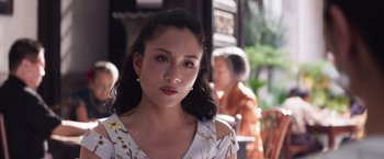 Movie still from “Crazy Rich Asians” (2018), directed by Jon M. Chu – A young woman is looking into the camera; Close Up shot, Over the shoulder angle