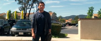 Movie still from “Crazy, Stupid, Love.” (2011), directed by Glenn Ficarra – A man holding a baseball glove on the side of the street; Medium shot, Low angle