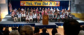 Movie still from “Crazy, Stupid, Love.” (2011), directed by Glenn Ficarra – A crowd of people sitting and standing in front of a podium; Extreme Wide shot, High angle