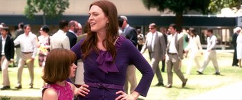 Movie still from “Crazy, Stupid, Love.” (2011), directed by Glenn Ficarra – A woman in a purple dress standing next to a crowd of onlookers; Medium shot, Over the shoulder angle