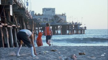 Movie still from “Crazy/Beautiful” (2001), directed by John Stockwell – Two people on the beach with garbage bags; Wide shot, Low angle