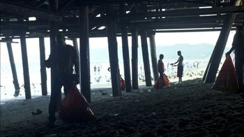 Movie still from “Crazy/Beautiful” (2001), directed by John Stockwell – A group of people standing on top of a sandy beach; Extreme Wide shot, Low angle