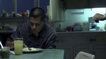 Movie still from “Crazy/Beautiful” (2001), directed by John Stockwell – A man sitting at a table eating a plate of food; Medium shot, High angle
