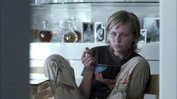 Movie still from “Crazy/Beautiful” (2001), directed by John Stockwell – A woman sitting on a chair holding a bowl; Medium shot, High angle