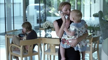 Movie still from “Crazy/Beautiful” (2001), directed by John Stockwell – A woman holding a child while talking on a phone; Medium shot, Over the shoulder angle