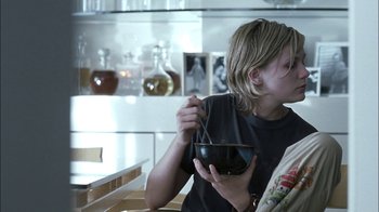 Movie still from “Crazy/Beautiful” (2001), directed by John Stockwell – A young boy is eating a bowl of food; Medium shot, Over the shoulder angle