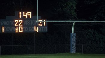 Movie still from “Crazy/Beautiful” (2001), directed by John Stockwell – A football field with an electronic sign on it; Extreme Wide shot, Over the shoulder angle