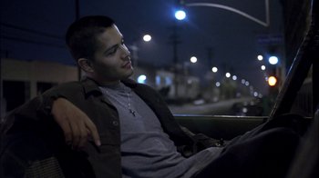 Movie still from “Crazy/Beautiful” (2001), directed by John Stockwell – A man sitting on a bench at night; Medium shot, High angle