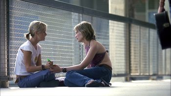 Movie still from “Crazy/Beautiful” (2001), directed by John Stockwell – Two women sitting on the ground talking to each other; Medium shot, High angle