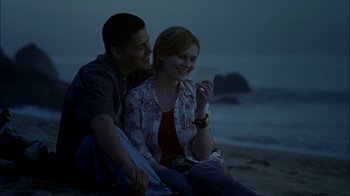 Movie still from “Crazy/Beautiful” (2001), directed by John Stockwell – A man and a woman sitting on the beach looking at something; Medium shot, High angle