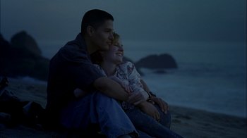 Movie still from “Crazy/Beautiful” (2001), directed by John Stockwell – A man and a woman sitting next to each other on the beach; Medium shot, High angle