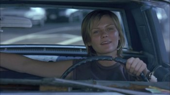 Movie still from “Crazy/Beautiful” (2001), directed by John Stockwell – A woman sitting in the driver's seat of a car; Close Up shot, Low angle