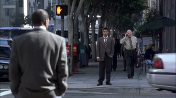 Movie still from “Crazy/Beautiful” (2001), directed by John Stockwell – A man standing on a sidewalk near a traffic light; Wide shot, Over the shoulder angle