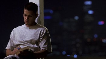 Movie still from “Crazy/Beautiful” (2001), directed by John Stockwell – A young man sitting in front of a window at night; Medium shot, High angle