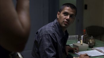 Movie still from “Crazy/Beautiful” (2001), directed by John Stockwell – A man sitting at a table in a dark room; Close Up shot, Over the shoulder angle