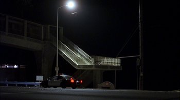 Movie still from “Crazy/Beautiful” (2001), directed by John Stockwell – A police car parked on the side of the road at night; Extreme Wide shot, Low angle