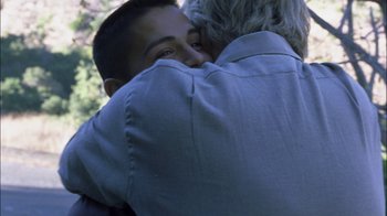 Movie still from “Crazy/Beautiful” (2001), directed by John Stockwell – A man hugging another man in a park; Close Up shot, Over the shoulder angle