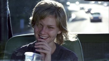 Movie still from “Crazy/Beautiful” (2001), directed by John Stockwell – A woman sitting in the back of a car holding a drink; Close Up shot, Over the shoulder angle
