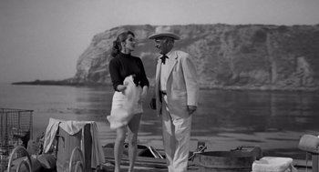 Movie still from “Creature from the Black Lagoon” (1954), directed by Jack Arnold – An old photo of a man and a woman standing on a boat; Medium shot, Low angle