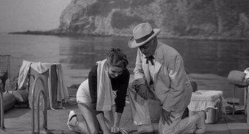 Movie still from “Creature from the Black Lagoon” (1954), directed by Jack Arnold – An older man and a young woman on a dock; Wide shot, High angle