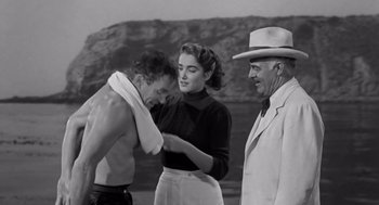 Movie still from “Creature from the Black Lagoon” (1954), directed by Jack Arnold – An old photo of a man and a woman and a man; Medium shot, Over the shoulder angle