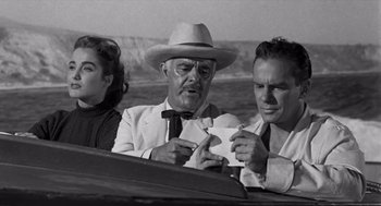 Movie still from “Creature from the Black Lagoon” (1954), directed by Jack Arnold – Two men and a woman sitting in a boat; Medium shot, Over the shoulder angle