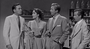 Movie still from “Creature from the Black Lagoon” (1954), directed by Jack Arnold – A man and a woman standing next to each other in front of another man; Medium shot, Over the shoulder angle