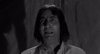 Movie still from “Creature from the Black Lagoon” (1954), directed by Jack Arnold – A black and white photo of a man with long black hair; Close Up shot, Low angle