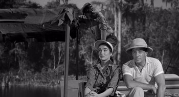 Movie still from “Creature from the Black Lagoon” (1954), directed by Jack Arnold – A woman sitting next to a man on a boat; Medium shot, High angle