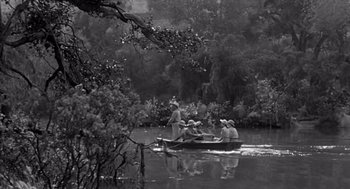 Movie still from “Creature from the Black Lagoon” (1954), directed by Jack Arnold – A black and white photo of people in a small boat; Extreme Wide shot, High angle