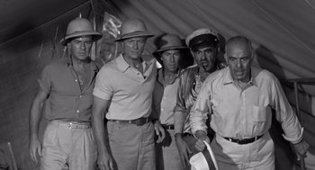 Movie still from “Creature from the Black Lagoon” (1954), directed by Jack Arnold – A black and white photo of a group of men in hats; Medium shot, Low angle