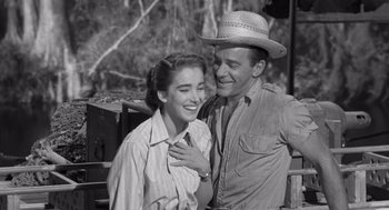 Movie still from “Creature from the Black Lagoon” (1954), directed by Jack Arnold – A man and a woman smiling for the camera; Medium shot, High angle