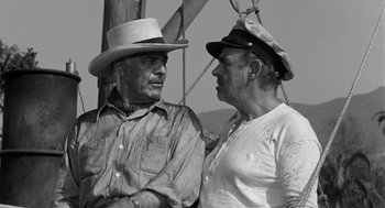 Movie still from “Creature from the Black Lagoon” (1954), directed by Jack Arnold – Two men in hats are talking on a boat; Medium shot, Over the shoulder angle