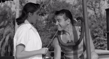 Movie still from “Creature from the Black Lagoon” (1954), directed by Jack Arnold – An old photo of a man and a woman talking to each other; Medium shot, Over the shoulder angle