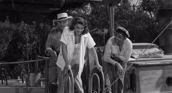 Movie still from “Creature from the Black Lagoon” (1954), directed by Jack Arnold – A black - and - white photo of a woman and two men; Wide shot, High angle