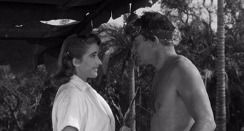 Movie still from “Creature from the Black Lagoon” (1954), directed by Jack Arnold – A man and a woman standing under an umbrella; Close Up shot, High angle