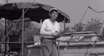 Movie still from “Creature from the Black Lagoon” (1954), directed by Jack Arnold – An older man holding a tennis racket under an umbrella; Medium shot, High angle