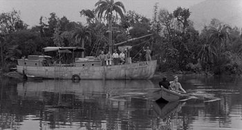 Movie still from “Creature from the Black Lagoon” (1954), directed by Jack Arnold – A group of people in a boat on a body of water; Extreme Wide shot, High angle